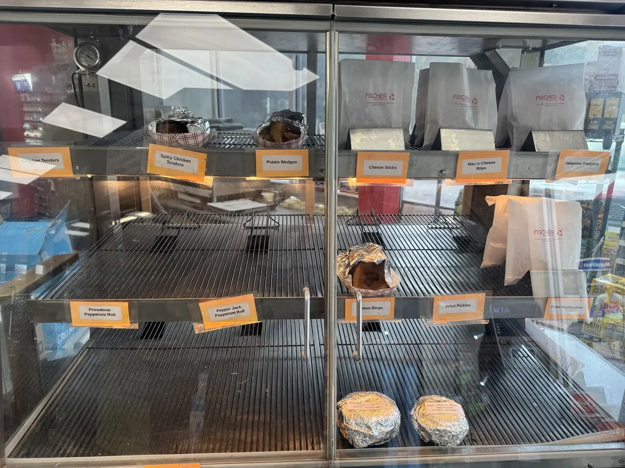 Hot food case with chicken tenders, potato wedges, pepperoni rolls, onion rings and other fried foods at Jack's